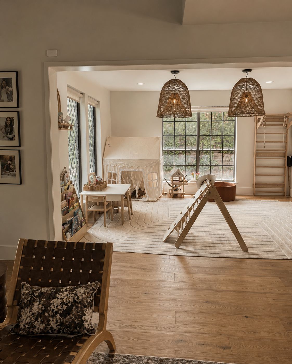 Playroom with woven pendants, climbing frame, play tent and a wall of books